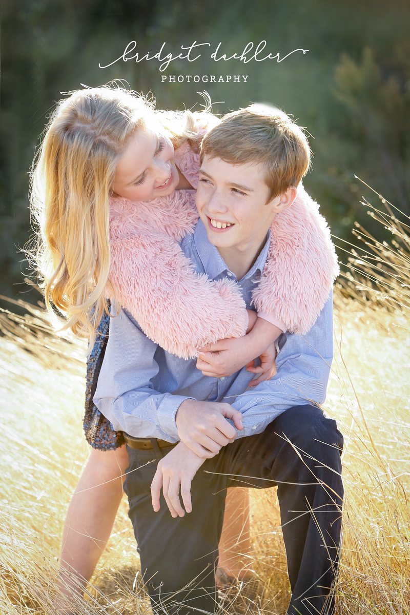 Family session portrait under live oaks at golden hour near Austin, Texas (vertical frame 5)