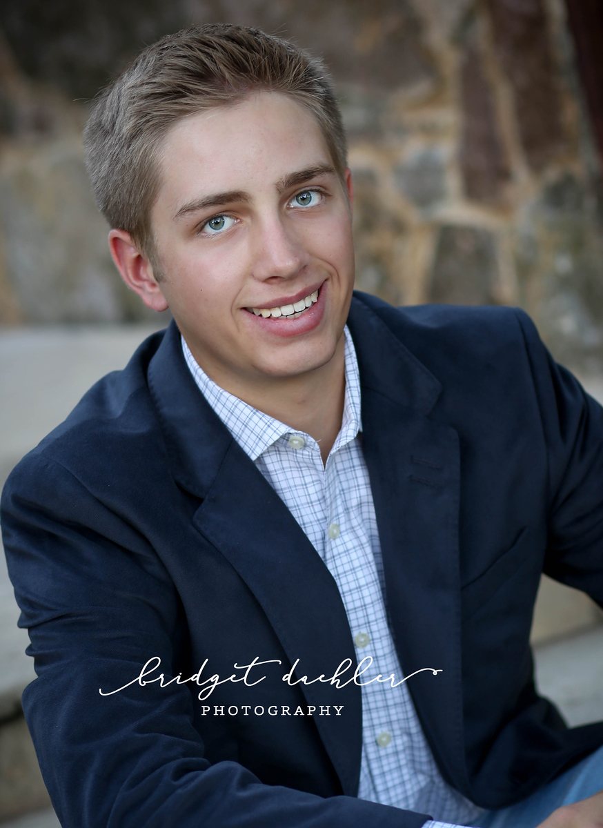 Outdoor senior session portrait framed by live oak trees in the Texas Hill Country (vertical frame 27, variation 3)