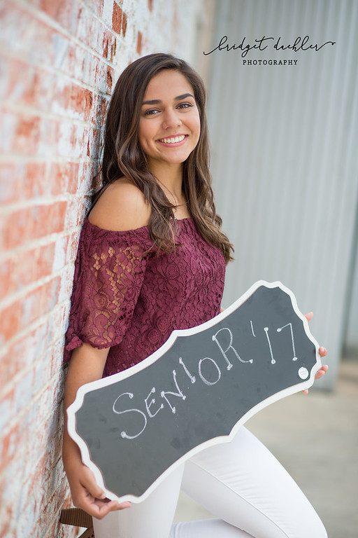 Senior portrait among wild grasses lit by low evening sun near Austin (vertical frame 46, variation 4)