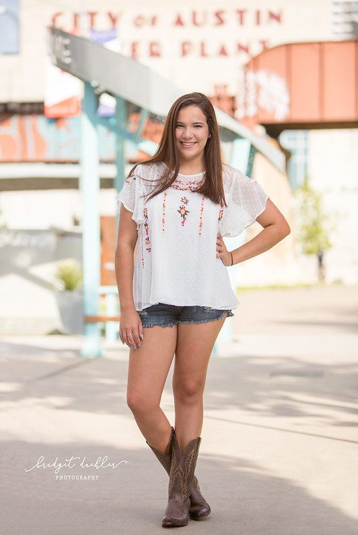 Senior portrait among wild grasses lit by low evening sun near Austin (vertical frame 34, variation 3)
