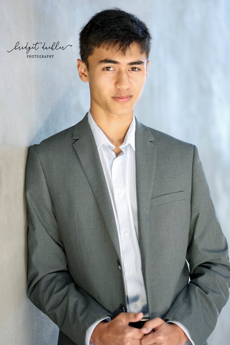 Senior portrait of a graduate posed against warm evening light in Austin, Texas (vertical frame 2)